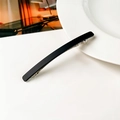 Dettaglio di un fermaglio per capelli nero opaco minimalista con molla in metallo argento - Nero