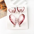 Detailed macro view of three lavender transparent butterfly hair clips on a white display stand - Transparent Wine Red Heart Set