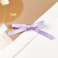 Detail of lavender satin bow hair clip with a smooth pearlescent texture and metal grip - Single Style / Purple