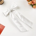 Elegant white silk bow hair clip with long ribbons on a minimalist white backdrop - White