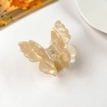 Detail view of pearlescent butterfly hair claw clip with golden metal spring and 3D design - Phantom Yellow