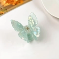 Macro shot of iridescent mint green butterfly hair claw with 3D resin wings and metal spring - Iridescent Green