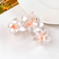 Dettaglio della molletta per capelli con fiori di plumeria sfumati rosa e perlescenti - Arancione Perlato