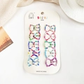 Gros plan de barrettes à cheveux colorées à motifs pour enfants sur carton blanc - Nœud Papillon Rayé