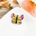 Détail d'une pince papillon dégradé rose et jaune avec nervures noires et strass brillants - Résine Mixte / Rayé Rose & Jaune