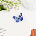 Détail d'un pendentif papillon en acrylique bleu saphir avec motifs d'ailes - Bleu