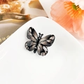 Détail macro de la pince papillon dégradée avec texture marbrée et strass brillants - Résine Mixte / Rayé Noir