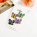 Détail de quatre barrettes papillon dégradées sur une carte avec motifs de nervures - Résine Mixte / Multicolore