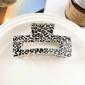 Dettaglio di una pinza per capelli quadrata con stampa leopardata su un vassoio di ceramica - Stampa Muccata Bianco Nero (8.5cm Quadrato)