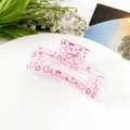 Detail of pink translucent acrylic hair claw clip with heart patterns on a white tray - Pink Heart (8.5cm Square)