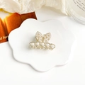 Dettaglio di un elegante fermaglio a farfalla con perle e strass su sfondo raffinato - Stile Orecchie di Coniglio in Perle
