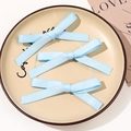 Three light blue ribbon bow hair clips on a ceramic tray with a ballet style aesthetic - Combination Style / Sky Blue
