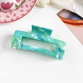 Detail view of large marble hair claw clip with green blue patterns on white background - Marble Emerald Green