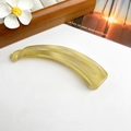 Détail d'une pince à cheveux banane en résine jaune translucide sur fond minimaliste - Pince Banane Croissant 12.5cm - Jaune Gelée