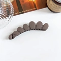 Gros plan d'une barrette banane marron mat festonnée sur un fond esthétique minimaliste - Pince Banane Os de Dragon 11cm - Café Foncé Mat