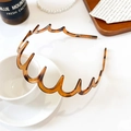 Detail of tortoise shell wavy headband resting on a coffee cup in a French style setting - Premium Wave Headband / Tortoiseshell Brown