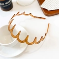 Dettaglio macro del cerchietto ondulato ambrato con finitura lucida in resina e design curvo - Cerchietto a Onda Premium / Pelle di Serpente Caffè