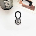 Close-up of vintage silver hair tie with turquoise inlay and ornate metal engraving - Antique Silver Rising Sun Black Turquoise