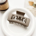 Detail of mocha brown matte hair claw clip on white tray with candle background - Matte Mocha