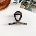 Gros plan d'une pince à cheveux motif léopard écaille sur un plateau de décoration - Pince à cheveux léopard - 8 cm Croisée Café Foncé