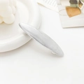 Detail of silver metallic geometric spring hair clip with fine brushed texture finish - Striped Oval Silver