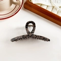 Macro view of leopard print hair claw clip with strong golden metal spring detail - Dark Leopard Retro Cross
