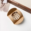 Detailed view of matte caramel hair claw clip with cutout design on a wooden background - Matte Ginger Coffee