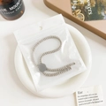 Detail of beige spiral textured adjustable hair tie in minimal Nordic lifestyle setting - Plastic/Resin / Threaded Adjustable Hair Tie - Gray Buckle Beige