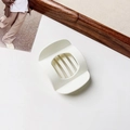 Close-up of cream matte hair claw clip with cutout design on a minimalist background - Matte Creamy White