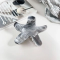 Dettaglio di molletta a forma di stella con trama in marmo grigio su sfondo di rivista elegante - 9cm Stella Marina - Marmo Grigio Chiaro