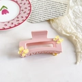 Close-up of pink resin hair claw with yellow butterfly accents on vintage paper - 9cm Pink Square - Yellow Butterfly