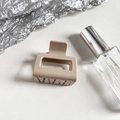 Close-up of matte beige square claw clip with frosted texture and hollowed-out design - Lotus Pink