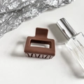 Detail of a brown square hollow hair claw clip with a glossy finish on a white background - Red Brown
