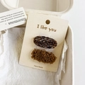 Detalle de dos pinzas para el pelo marrones de punto y felpa en tarjeta en caja de regalo - Ovalado Amarillo Jengibre