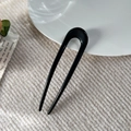 Minimalistische schwarze U-förmige Haarnadel für Dutts auf beigem Strickstoff - 11.5cm U-Form Haarstab / Glänzendes Schwarz