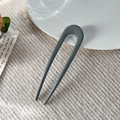 Detailansicht einer dunkelgrauen U-förmigen Haarnadel auf minimalistischem weißem Stoff - 11.5cm U-Form Haarstab / Glänzendes Graublau