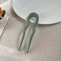 Close-up of matte bean green U-shaped hair pin with wave design on textured fabric - Matte Fruit Green