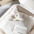 Primer plano de pinza de pelo de flor beige mate sobre papel blanco en una caja - Nudo Retorcido 4cm / Blanco Crema Mate