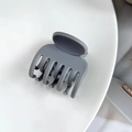 Detail view of a dark grey matte hair claw clip with a 7-tooth non-slip ergonomic design - Gray