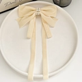Dettaglio del fermaglio a fiocco in velluto con perle e lunghi nastri eleganti - Velluto Perla Doppio Nastro Beige