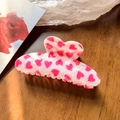 Dettaglio mollettone bianco perlato con cuori rosa posizionato su superficie in legno - Cuore Rosa