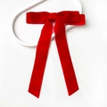 Macro detail of red velvet bow hair clip with long ribbons on a white display tray - Bright Red (Tie Style)