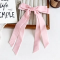 Barrette à cheveux avec nœud en velours rose et longs rubans sur un plateau à bijoux - Rose Clair
