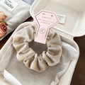 Detailed view of beige velvet scrunchie in gift box with pink heart tag and floral decor - Beige