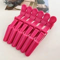 Detail of six professional rose pink alligator hair clips for salon styling and sectioning - Dusty Rose