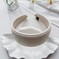 Vista detallada de la diadema ancha de cuero PU crema con costuras blancas elegantes - Beige Liso