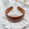 Detalle de la diadema de cuero PU marrón caramelo con costuras finas y textura suave - Caramelo Liso