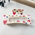 Detail of square hollow hair claw with colorful heart and bow prints on white glossy surface - 8.5cm Heart Print - Style J White Base / PS
