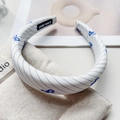 Dettaglio del cerchietto con farfalla blu con cuciture e etichetta Hand Made - Bianco