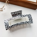 Detailed view of square claw clip with black and white leopard pattern on leather surface - Leopard White Base